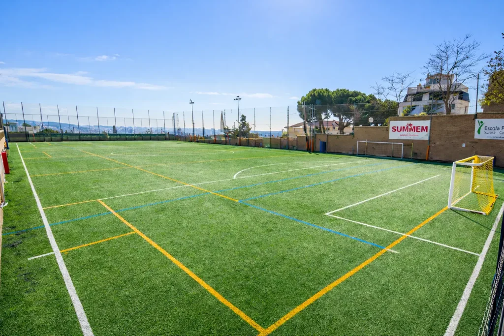 Campo de fútbol 7 en la Escola Pia Sarrià, con césped artificial, líneas reglamentarias y porterías en una instalación abierta en Barcelona